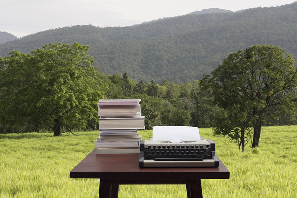 typewriter-stack-of-books-paper-in-garden-great-outdoors-nature